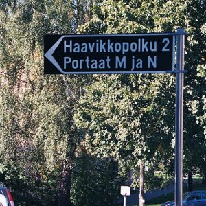 Mustaksi maalattu alumiininen tienviitta kiinteistöopasteena.